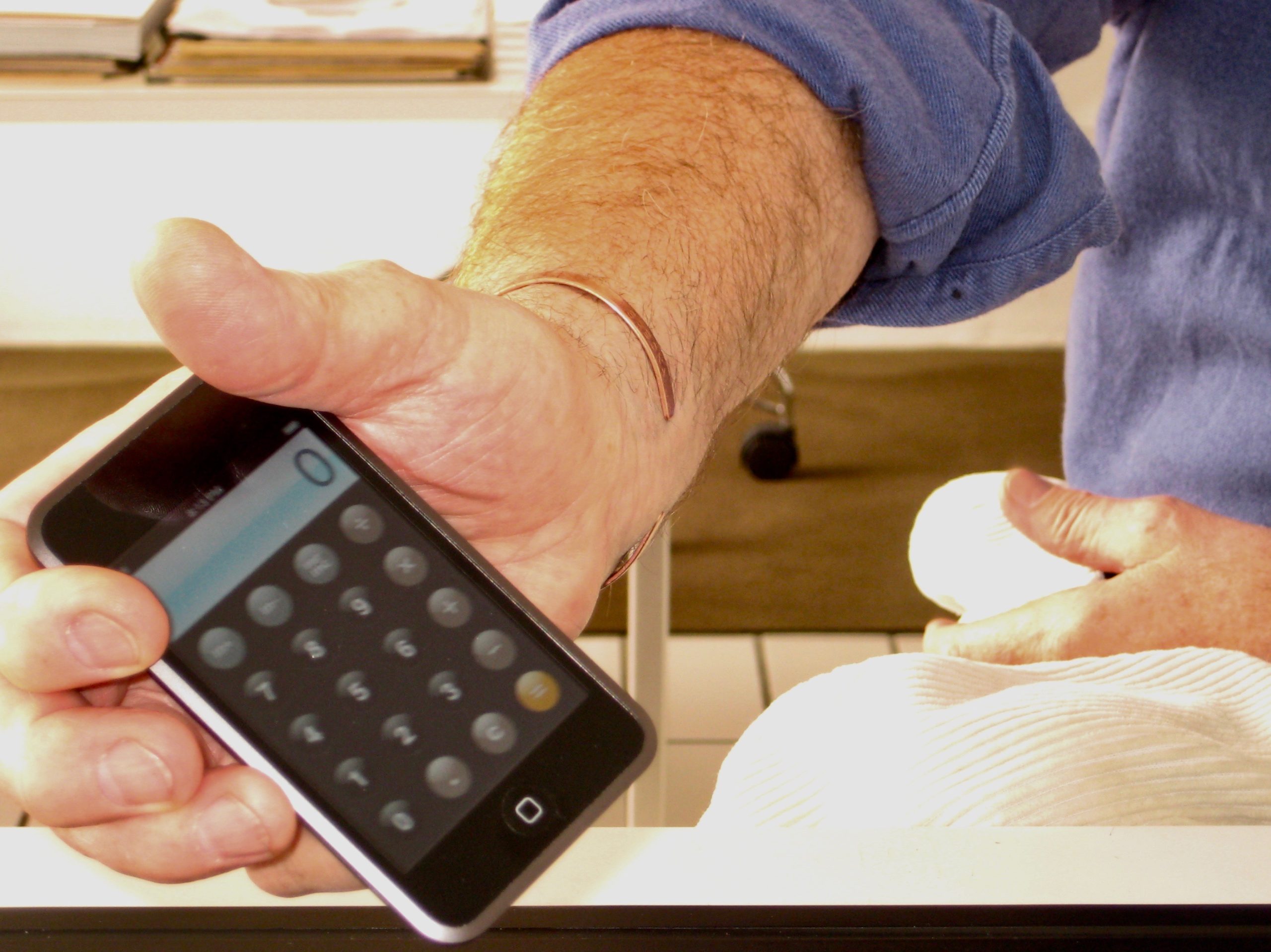 Dieter Rams hand with the calculater app of the iPhone