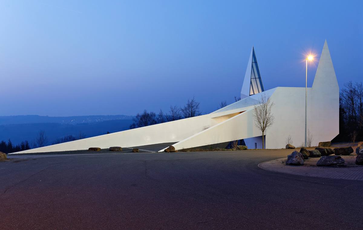 Viewed from the outside, the multifaceted shape of the building takes up the traffic sign pictogram for motorway churches — on the other hand, the church spires appear like the ears of a fox.